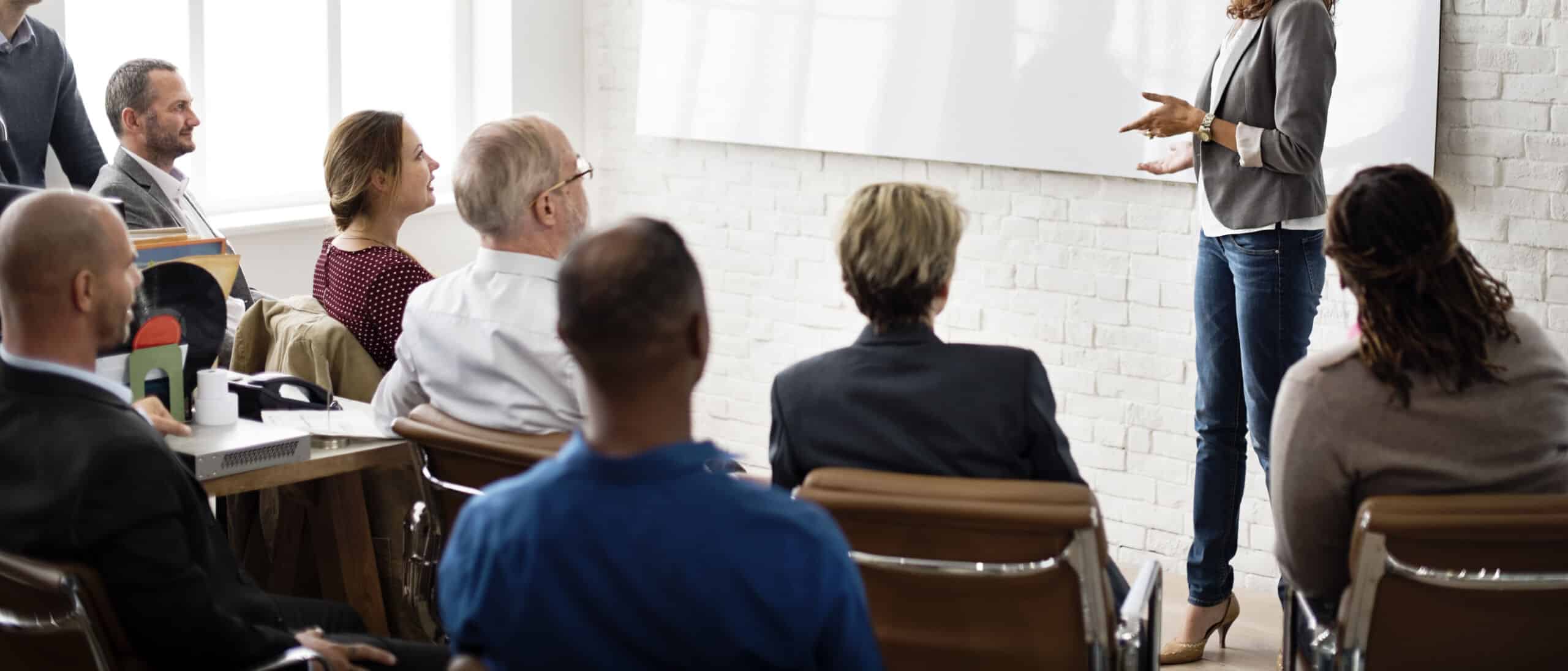 Woman giving a presentation to a group of people sat on chairs