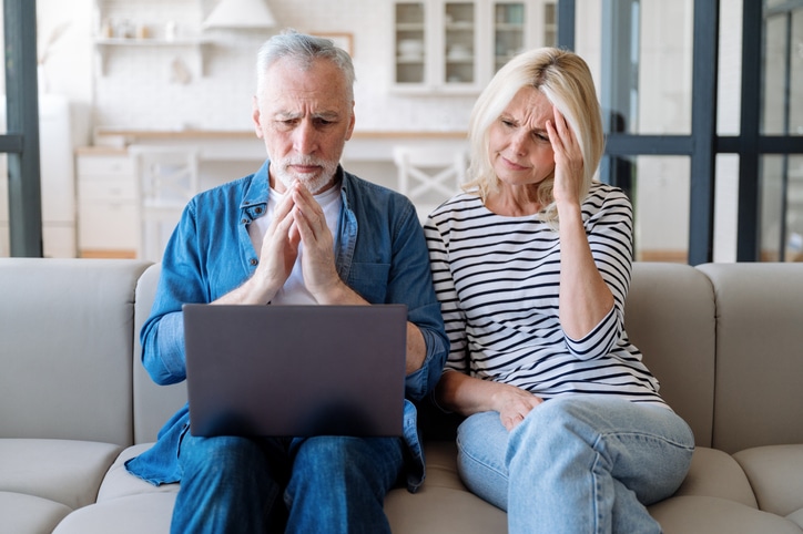 Puzzled couple tring to fill in an online risk questionnaire