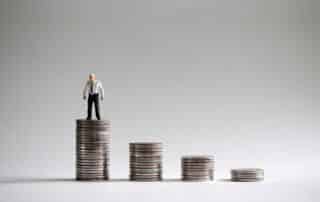 Mans standing on a pile of coins