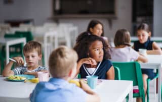 Child sitting at a kids table looking wistful