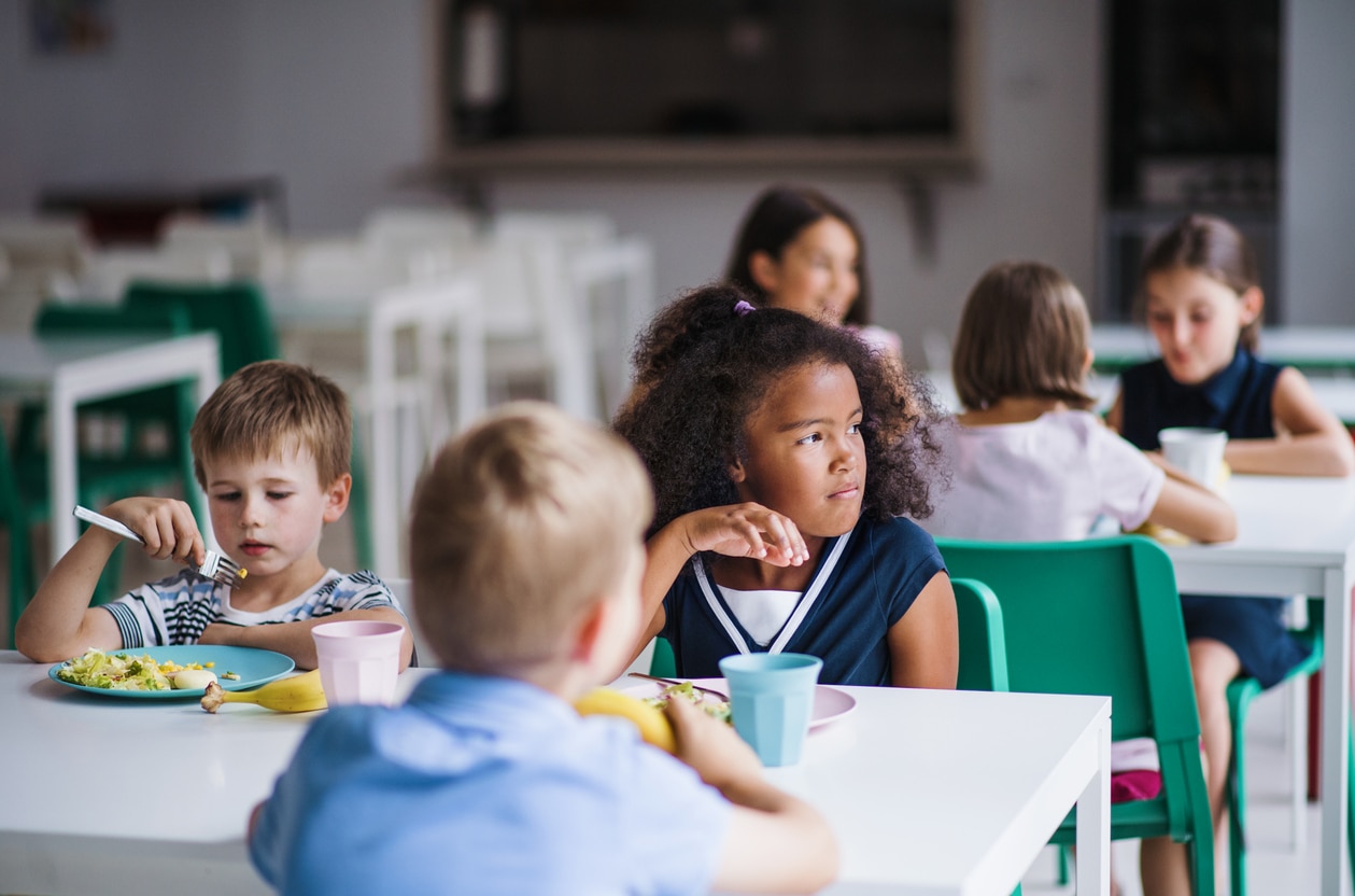 Child sitting at a kids table looking wistful